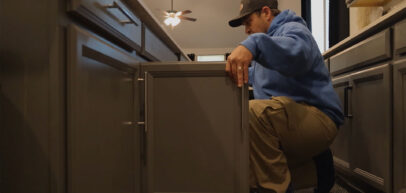 Technician checking under kitchen cabinets